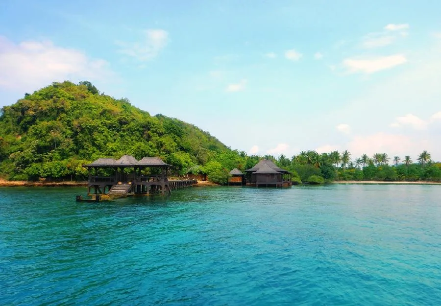 Clear green water and a wooden jetty at Pulau Pahawang, Lampung